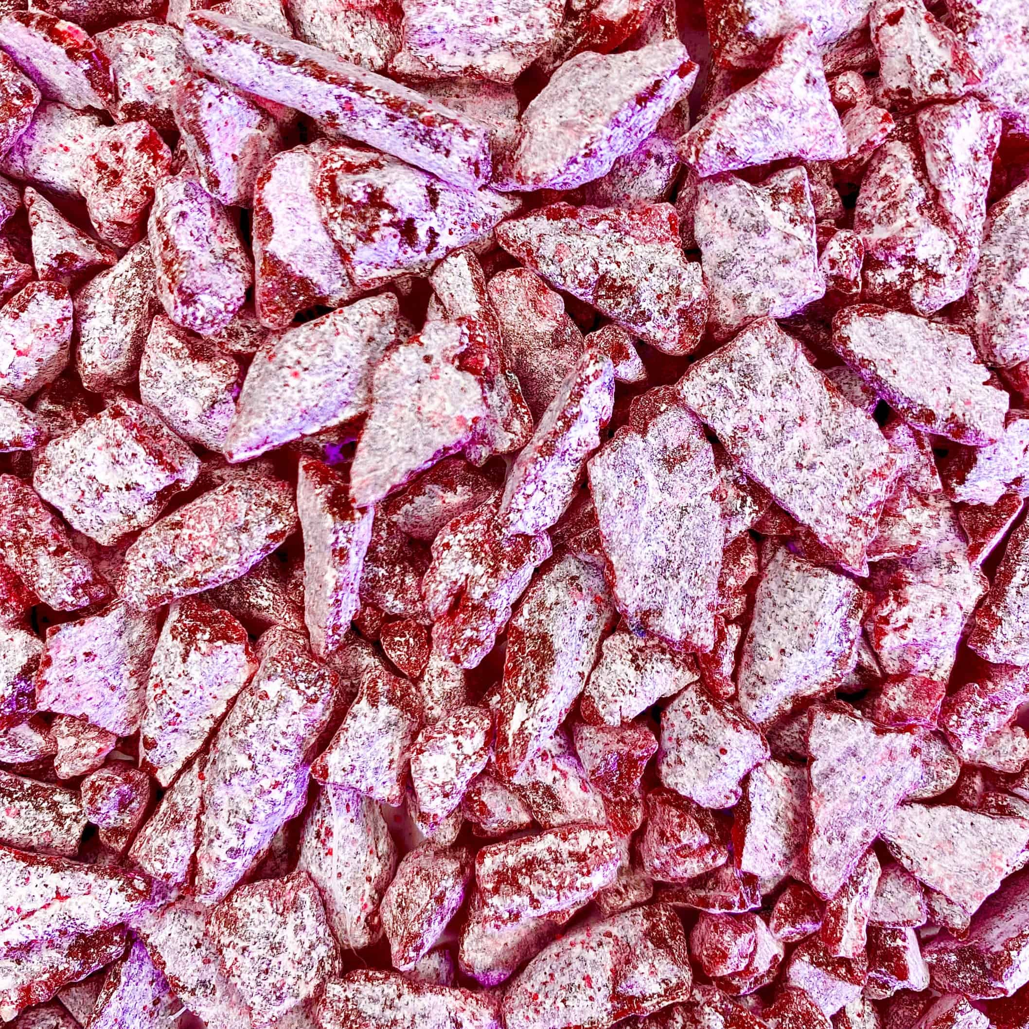 Nahaufnahme der Weihrauch Pink Rose-Bonbonstücke, schimmernd mit einer kristallinen Zuckerschicht, die an den zarten Reiz von Rosenblättern erinnert.