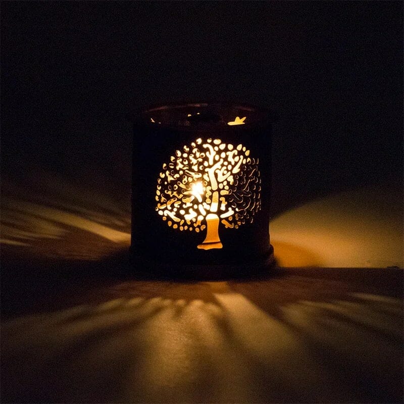 Ein Kerzenhalter aus Metall mit einem Baum darauf.