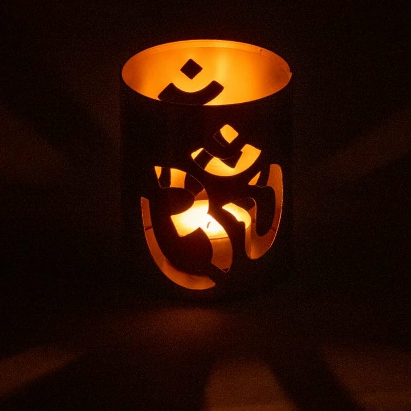 Ein Kerzenhalter mit einem Om-Symbol darauf.