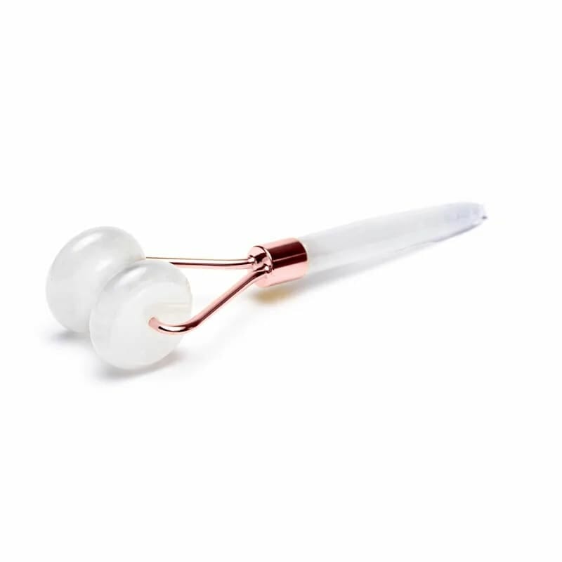 Eine weiße Kugel mit roségoldenem Griff auf einer weißen Oberfläche.
