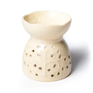 Ein kleiner Ölwärmer aus Keramik mit einem Loch in der Mitte.
