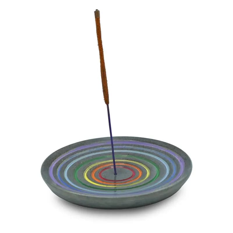Ein bunter Räucherstäbchenhalter mit einem Stäbchen darin.