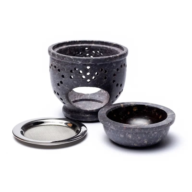 Ein schwarzer Steinbrenner mit einer Metallschale.