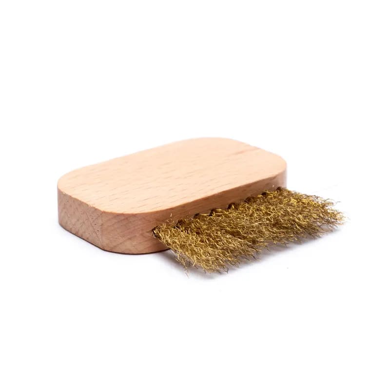 Eine Holzbürste mit goldenen Borsten auf weißem Hintergrund.